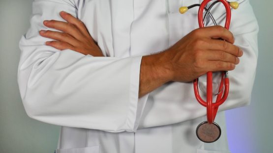Picture of doctor holding red stethoscope
