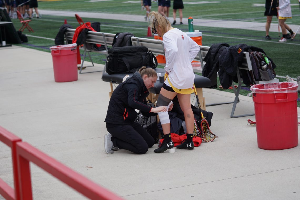 Girl getting her knee taped at a soccer game