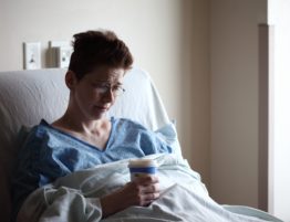 woman on hospital bed holding a coffee cup
